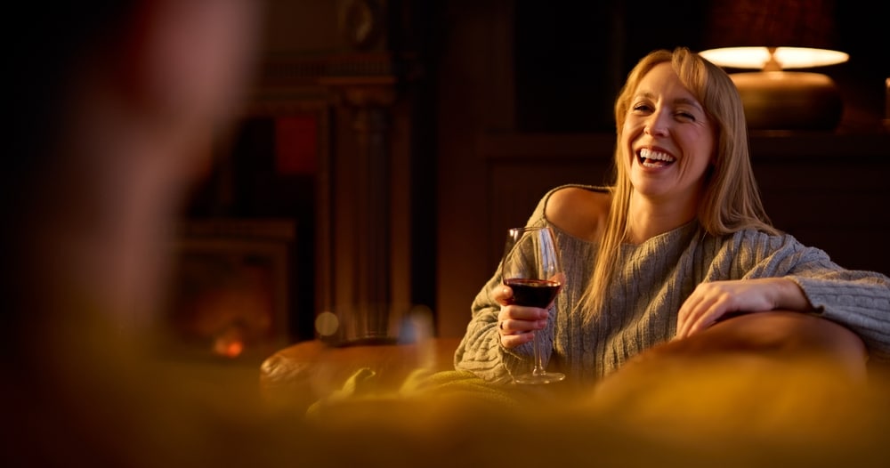 Couple drinking wine by the fire at our Bed and Breakfast, one of the most romantic getaways in Wisconsin