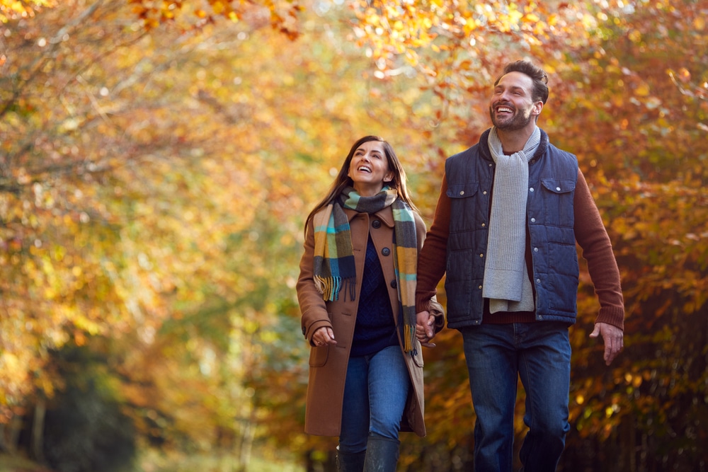 Couple hiking in the woods during their fall getaways near Chicago