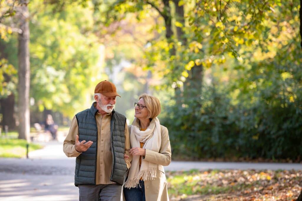 Stroll along the downtown Riverwalk in West Bend during one of the best weekend getaways in Wisconsin. This couple is walking through the park, deep in conversation.